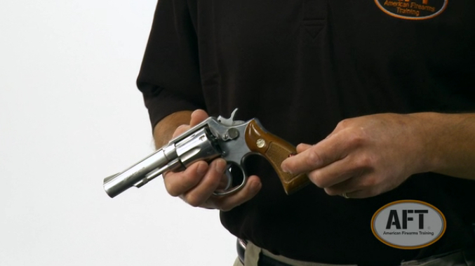 An AFT instructor offering a safety demonstration on a revolver.